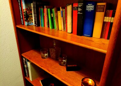 Regal mit diversen Büchern und einem Whiskyset